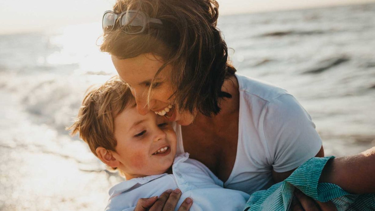 Hooggevoelige vrouw met hooggevoelig kind op het strand om te ontprikkelen